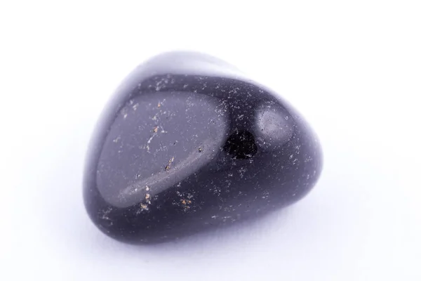 Pedra mineral macro ônix preto contra fundo branco — Fotografia de Stock