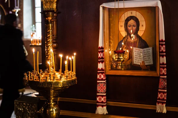 Church candles burn in a candlestick against the backdrop of ico — Stock Photo, Image