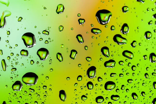 Beautiful multi-colored water droplets on a glass Stock Image