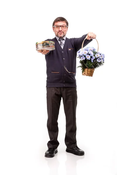 A handsome man in a suit and glasses, with sweets and flowers; W — Stock Photo, Image