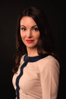 Karanlık bir arka plan üzerinde bej elbiseli güzel kız