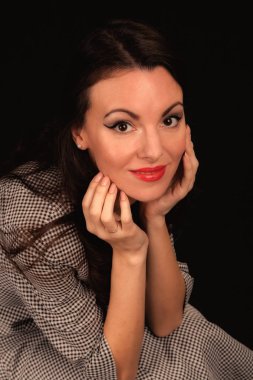 Karanlık bir arka plan üzerinde takım elbiseli güzel kız