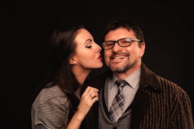 Bir adam bir kız karanlık bir arka plan karşı sarılma