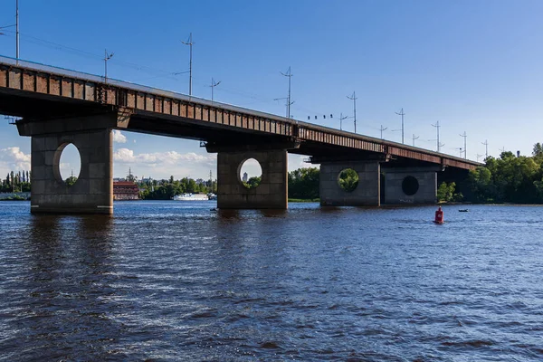 Brug over een rivier tegen een blauwe lucht en de wolken — Stockfoto