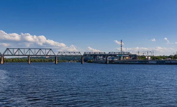 Järnvägsbro över floden där tåget färdas — Stockfoto