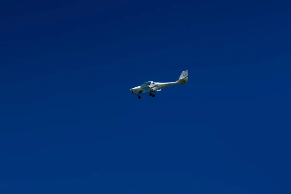 O avião voa no céu azul — Fotografia de Stock