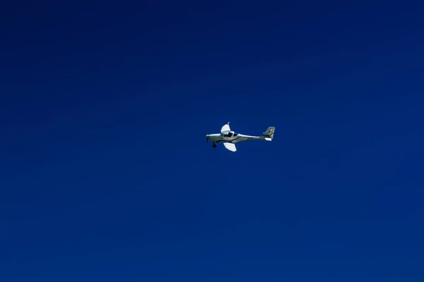 The plane flies in the blue sky — Stock Photo, Image
