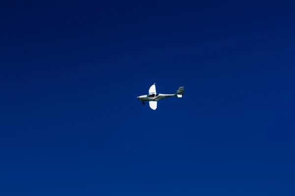 The plane flies in the blue sky — Stock Photo, Image