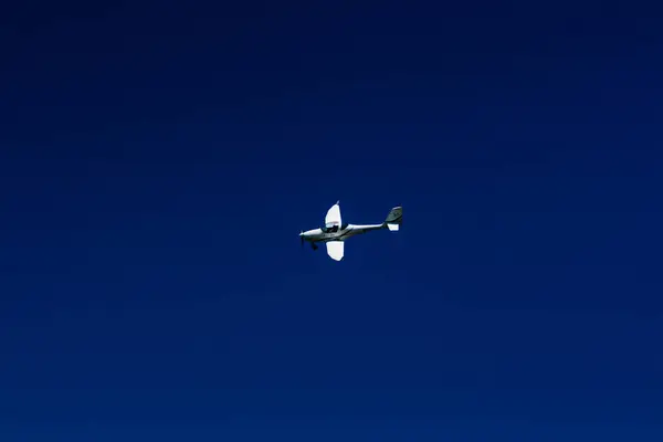 The plane flies in the blue sky — Stock Photo, Image