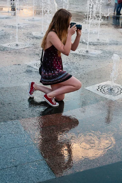 Hermosa chica toma fotos en una fuente — Foto de Stock