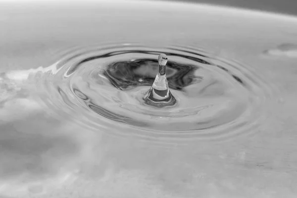 Vallende druppels in water — Stockfoto