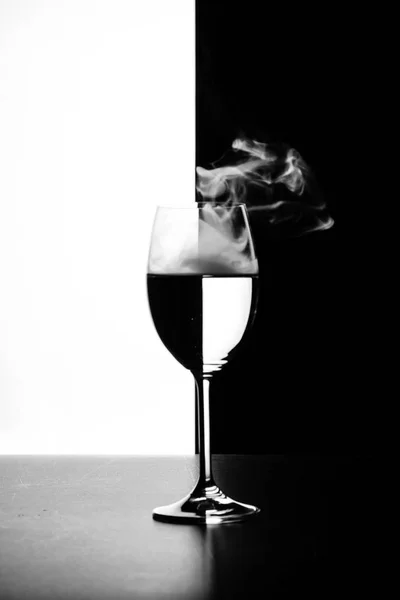 Sklenici vody a kouře na černé a bílé pozadí — Stock fotografie