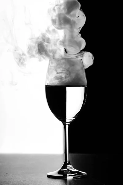 Sklenici vody a kouře na černé a bílé pozadí — Stock fotografie