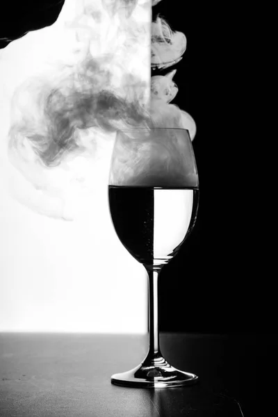 Ett glas vatten och rök på en svart och vit bakgrund — Stockfoto