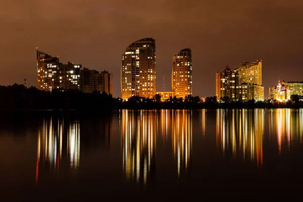 Nachtstadt mit Spiegelung der Häuser im Fluss — Stockfoto