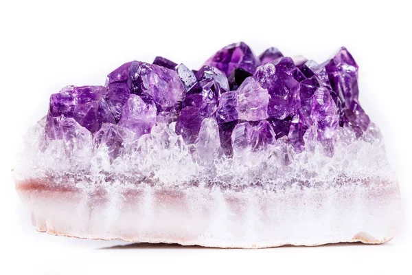 Macro mineral stone purple amethyst in crystals on a white backg