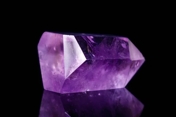 Macro mineral stone Amethyst crystal on a black background