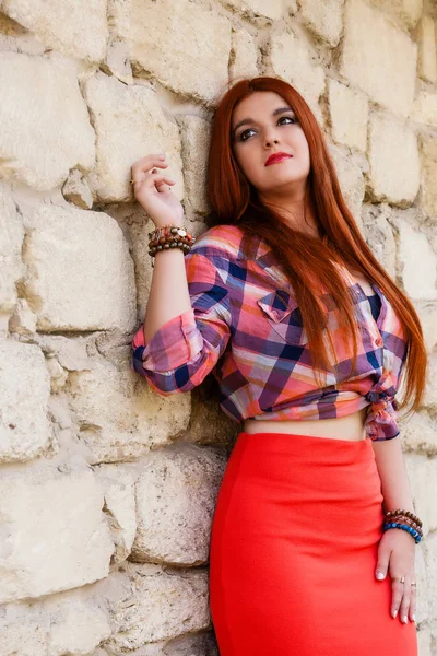 beautiful girl with orange hair in plaid shirt and red - pink sk