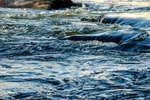 Flusso di acqua e spruzzi da una pietra — Foto Stock