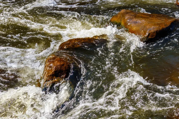 Fluxo de água e borrifo de uma pedra — Fotografia de Stock