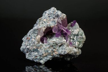 Siyah zemin üzerinde kayadaki makro mineral ametist taşı