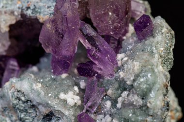 Siyah zemin üzerinde kayadaki makro mineral ametist taşı