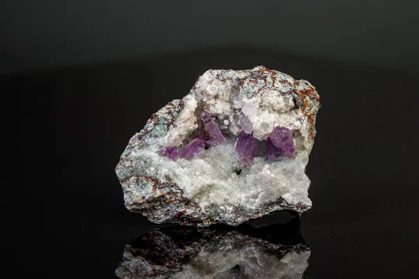 Pedra de ametista mineral macro em rocha sobre um fundo preto — Fotografia de Stock