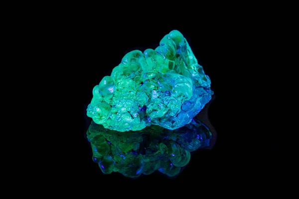 Opala de pedra mineral macro abaixo da luz ultravioleta em umas costas pretas — Fotografia de Stock