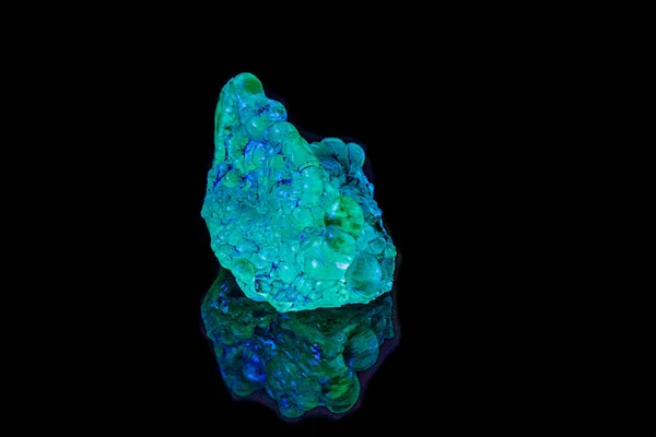 Opal z kamienia makromineralnego w świetle ultrafioletowym na czarnym grzbiecie — Zdjęcie stockowe