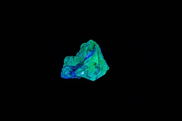 Makro-Mineralstein-Opal unter UV-Licht auf schwarzem Rücken — Stockfoto