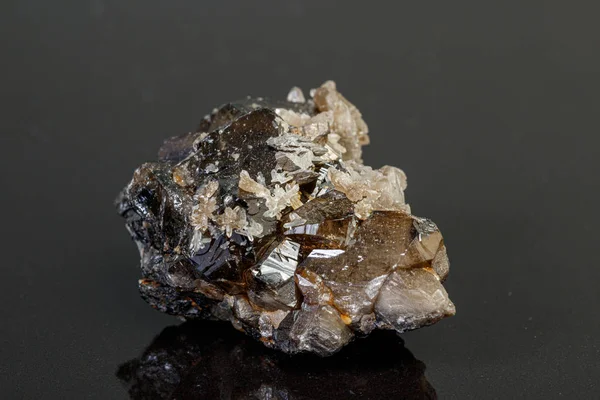 Pietra macrominerale cassiterite su sfondo grigio — Foto Stock