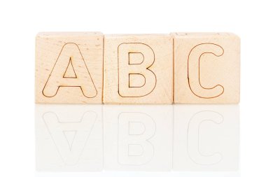 Beyaz zemin üzerinde Abc harfleri olan tahta küpler. 