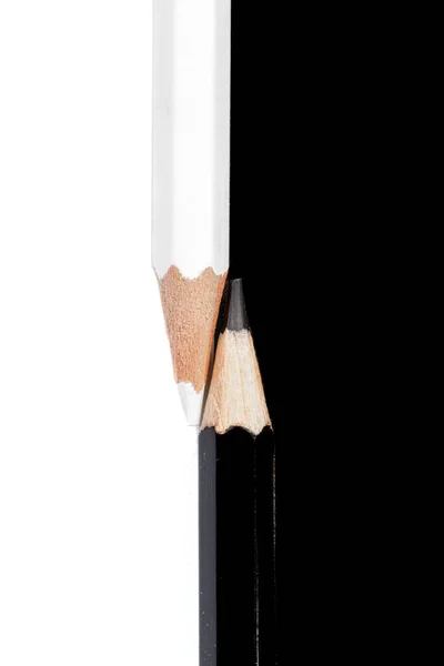 Weiße und schwarze Bleistifte auf weißem und schwarzem Hintergrund — Stockfoto