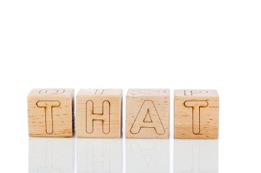 Beyaz arka planda yakın plan şeklinde harflerle tahtadan küpler.