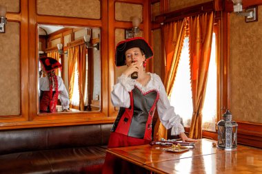 Steampunk kostümlü güzel bir kız eski bir tren vagonunda yakın planda.