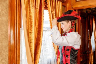 Steampunk kostümlü güzel bir kız eski bir tren vagonunda yakın planda.