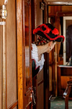 Steampunk kostümlü güzel bir kız eski bir tren vagonunda yakın planda.