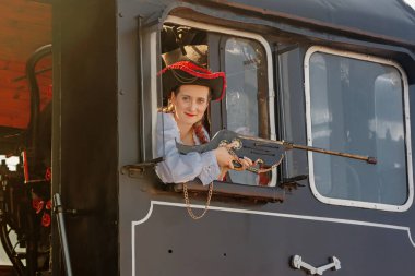 Eski bir trenin arka planında Steampunk takım elbiseli güzel bir kız.