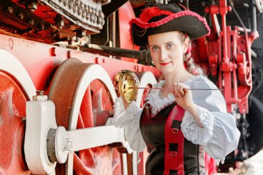 Eski bir trenin arka planında Steampunk takım elbiseli güzel bir kız.