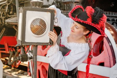 Eski bir trenin arka planında Steampunk takım elbiseli güzel bir kız.