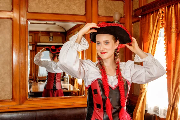 beautiful girl in steampunk costume in an old train carriage close-up