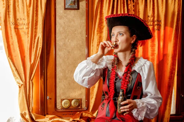 beautiful girl in steampunk costume in an old train carriage close-up