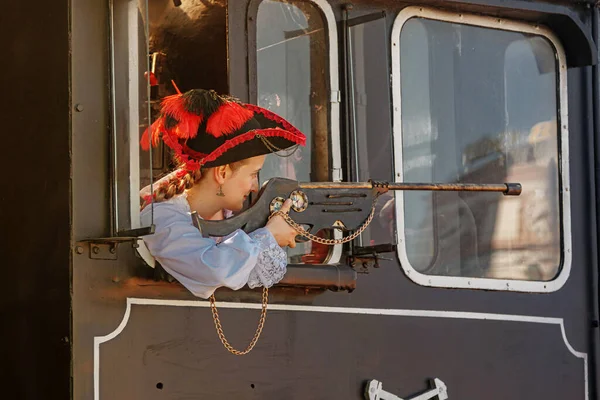 beautiful girl in a steampunk suit on a background of an old train close-up