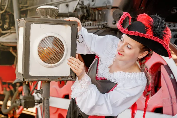 beautiful girl in a steampunk suit on a background of an old train close-up