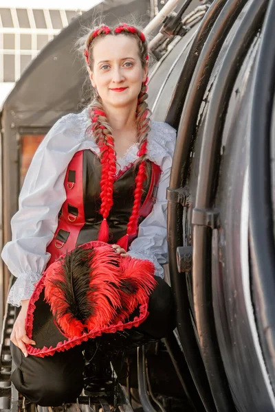 beautiful girl in a steampunk suit on a background of an old train close-up