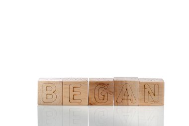 Tahta küplerin harfleri beyaz arka planda yakın plan çekimde başladı.