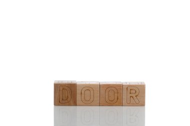 Beyaz arka planda harf kapılı tahta küpler.