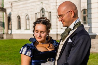 Şatonun arka planında eski moda elbiseli bir adamla güzel bir kız. Yakın plan.