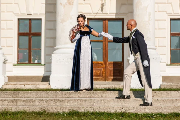 Şatonun arka planında eski moda elbiseli bir adamla güzel bir kız. Yakın plan.