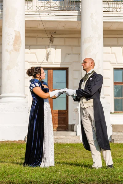 Şatonun arka planında eski moda elbiseli bir adamla güzel bir kız. Yakın plan.